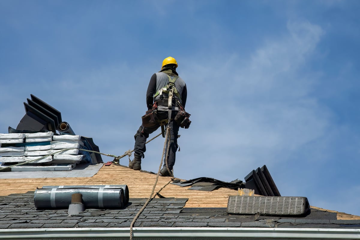 Roofing website hero showing a roofer at work